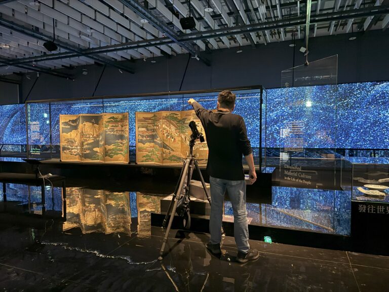 拍攝展場環景攝影工作，相機置放於腳架上，背景為展場